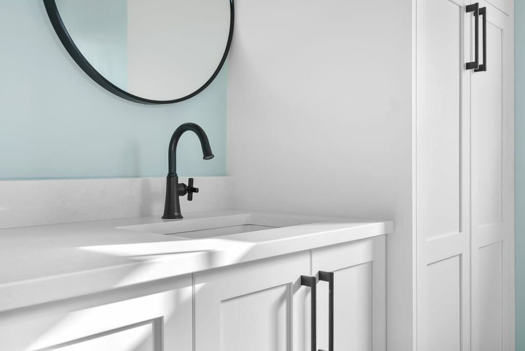 A renovated bathroom with linen storage cabinet.