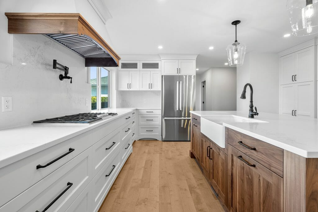 View of the entire newly renovated kitchen with white cabinets and wood-finished kitchen island.